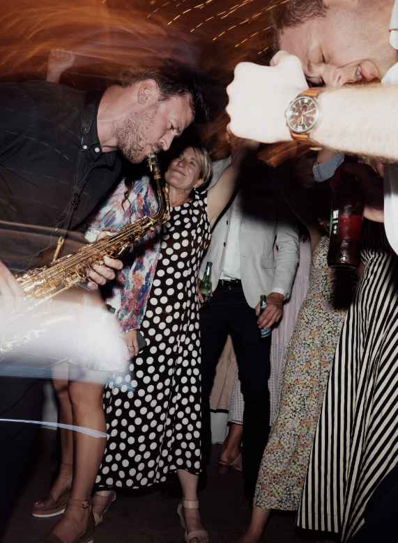 Sax player performing among guests on the dancefloor
